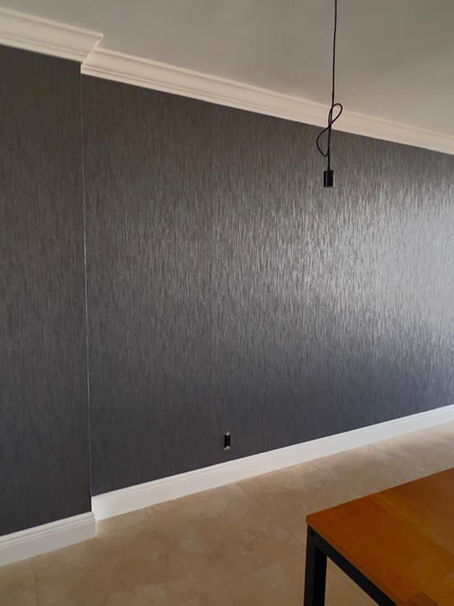     Complete view of a modern luxury living room at 200 Leslie Condominium featuring TWC-3250 charcoal wallpaper near me installed on a main accent wall behind a neutral taupe sofa.