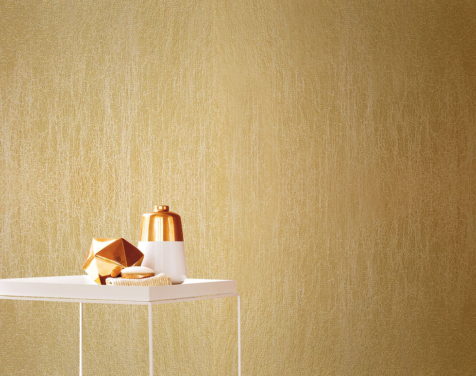 Minimalist white table holds a copper accent vase and decor against gold textured wall, creating a warm, luxurious ambiance.