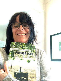 Une lectrice avec le roman Perdue à Maui de l'auteure Marilyn Montplaisir