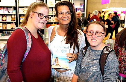 L'auteure Marilyn Montplaisir avec des lectrices dans un salon du livre