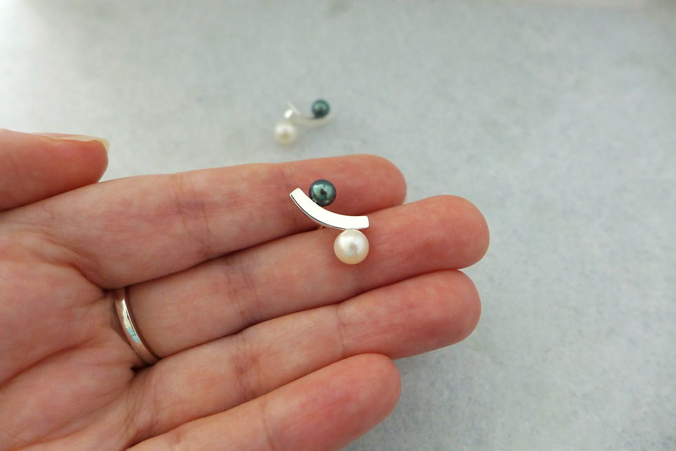 Miniatura: um brinco em prata com duas pérolas de diferentes tamanhos e cores