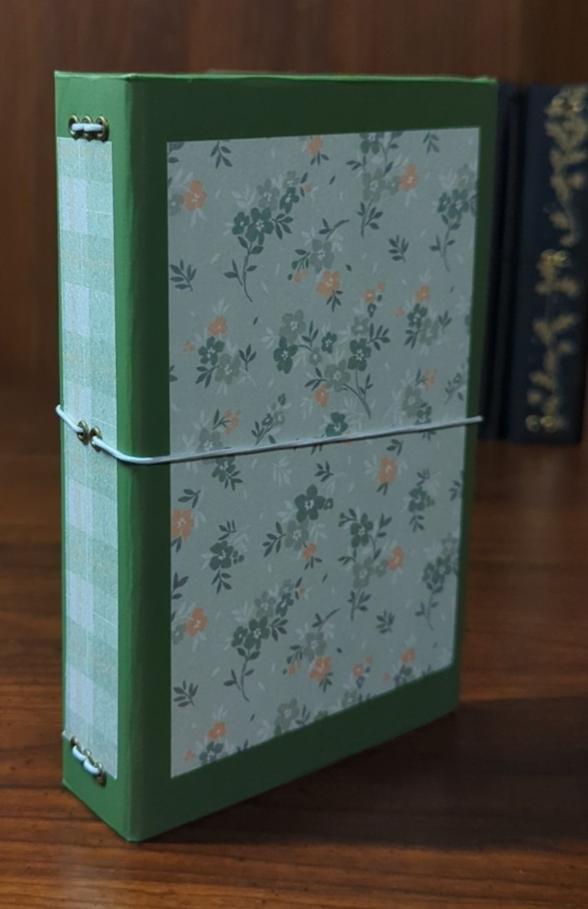 Side view of a green floral refillable notebook (4x6) cover