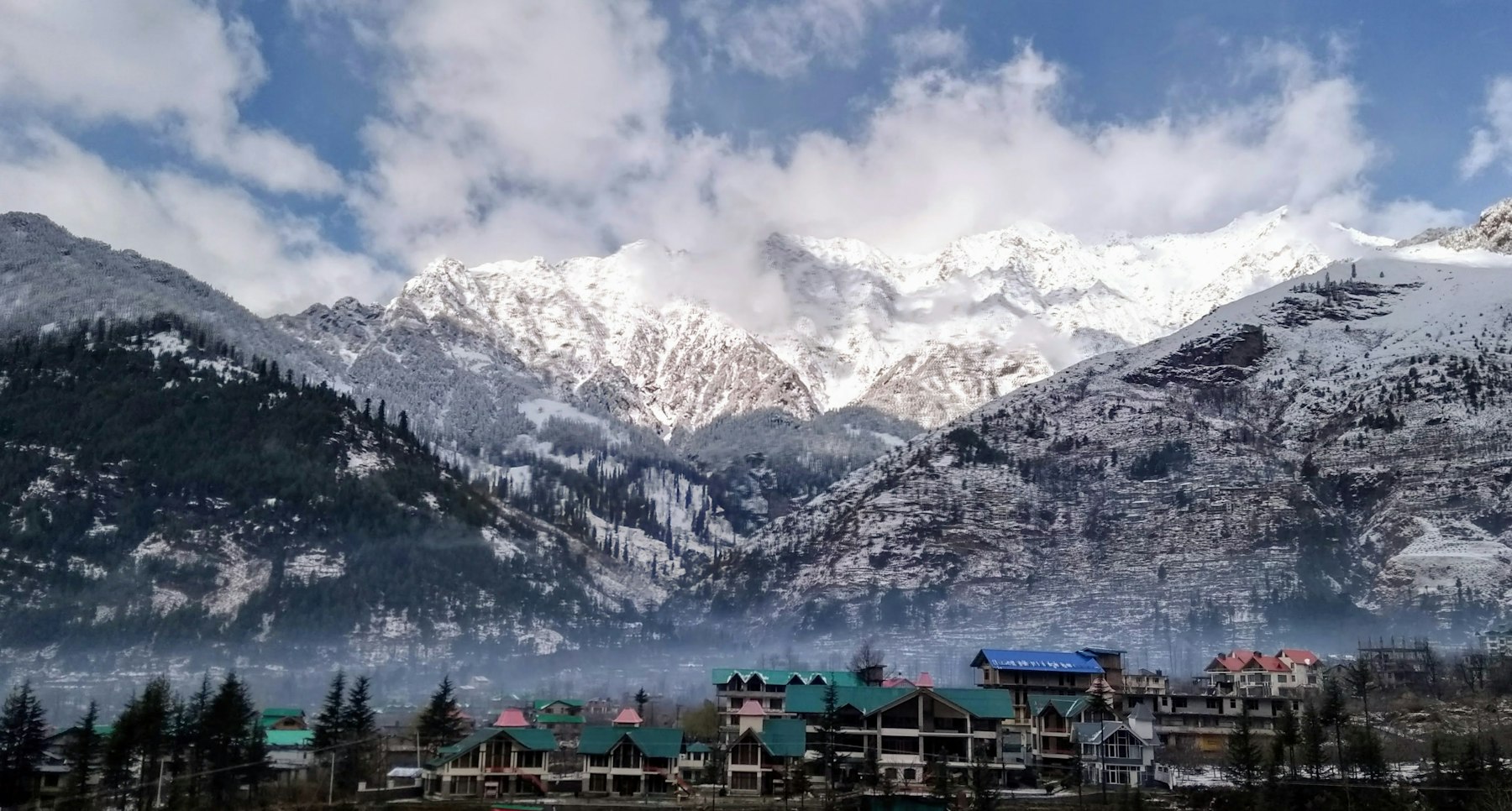 Town beneath snow-covered mountains in Himachal Pradesh