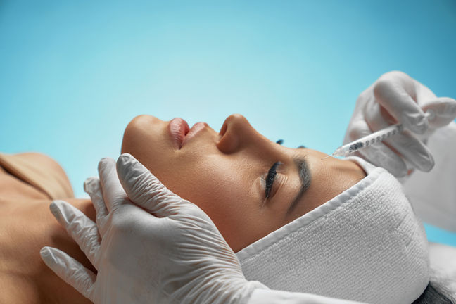 Woman receiving facial injections, cosmetic procedure