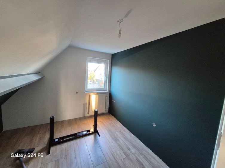 Geschilderde slaapkamer met donkergroene accentmuur en wit plafond in Zelhem