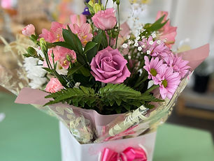 a bubble bag bouquet of mixed pink and white flowers with a pink bow