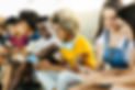 Multiethnic group of young friends using mobile phone while sitting on urban stairs - Happ