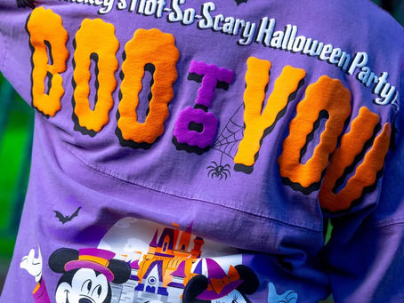 Person wearing a purple Halloween shirt featuring Mickey and Minnie in costumes, and text reading "Mickey's Not-So-Scary Halloween Party, BOO TO YOU."