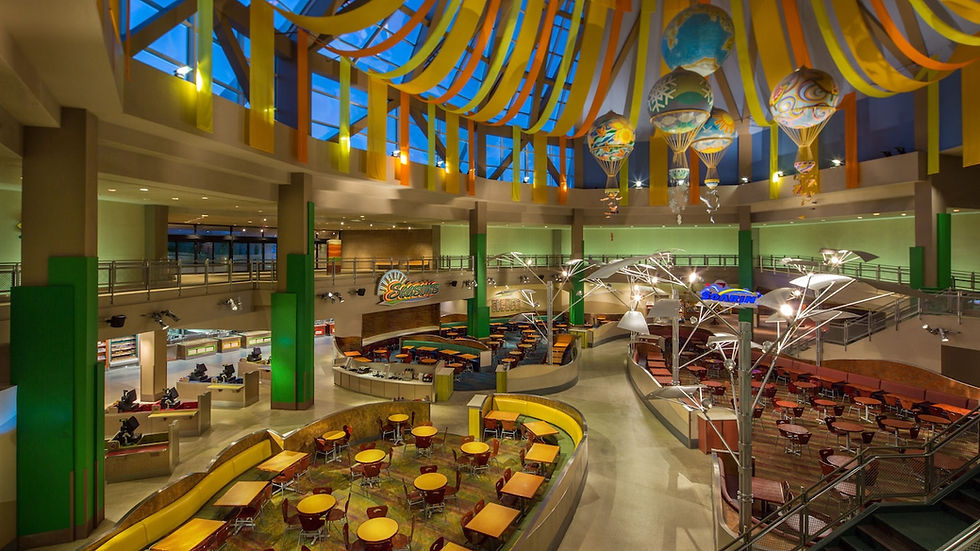 Bright food court with colorful hanging banners and hot air balloons. Circular tables and chairs fill the space. Signs for "Seasons" and "Soarin'."