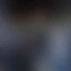 Four adults stand together smiling under a covered walkway at a Disney park, each wearing themed T-shirts from the Passport Collection. The shirts feature colorful, metro-inspired graphics with Disney park references, including designs labeled “Destination Tomorrow,” “Destination Fantasy,” and “Destination Imagination.”