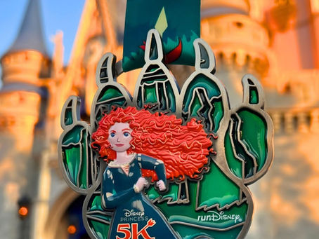 Medal with a character and text "Disney Princess 5K 2026" hangs against a castle backdrop. The design features bold green and red colors.