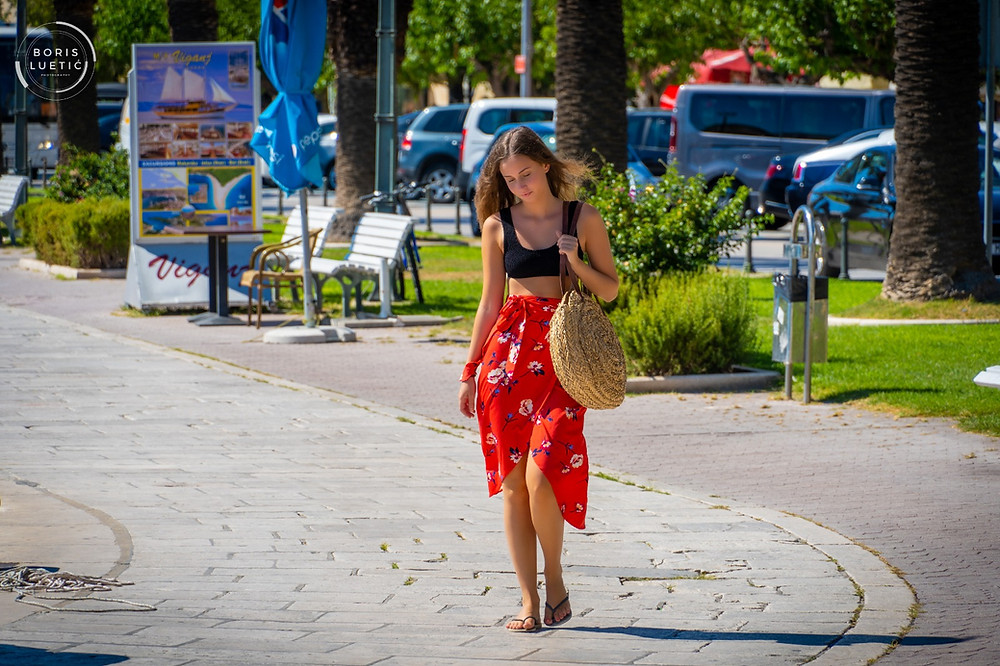 Beautiful girl walking around Makarska harbor