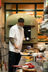 chef inside the kitchen with a pizza oven