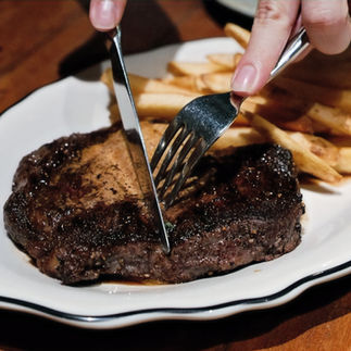 girl slicing ribeye steak
