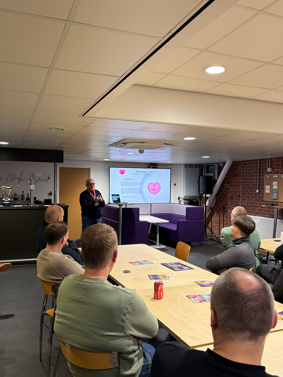 Tommy Knott, Trustee, giving a presentation on the "Take Heart" charity to attentive G&H staff.