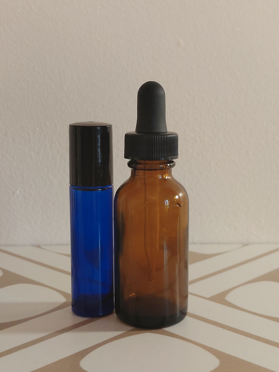 A blue roll on bottle and an amber dropper bottle