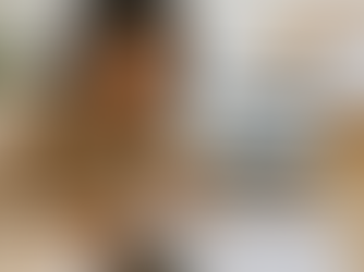 Person with dreadlocks reviewing documents at a desk. Laptop open to a website, calculator nearby. Corkboard with "Checklist" in background.