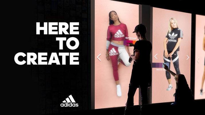 Girls select different outfits by using Adidas touchscreens