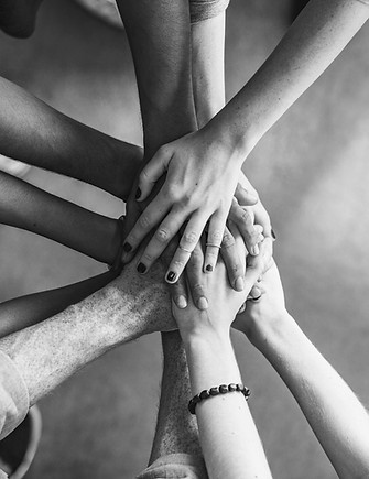Top view of people putting their hands on top of each other.