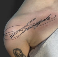 Script tattoo on shoulder and small arm tattoo