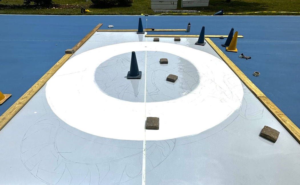 Placing the logo Stencil on the basketball court.