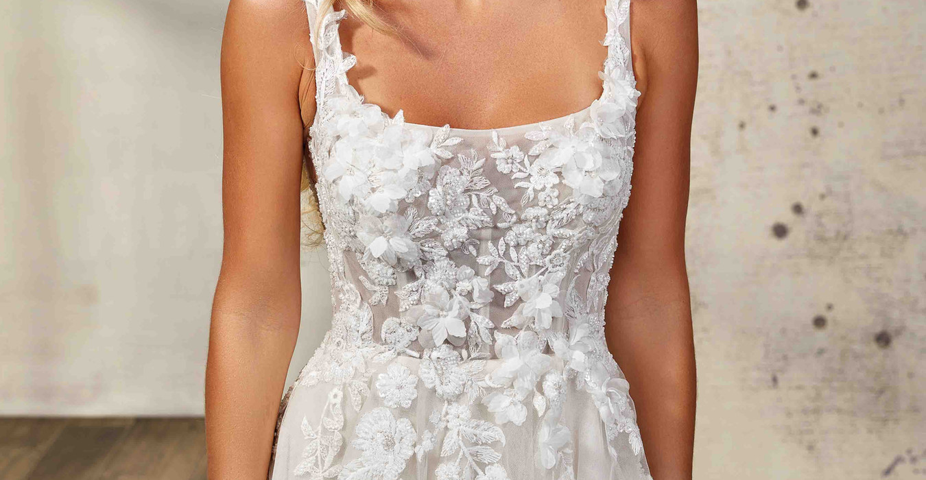 Eddy K wedding gown with slit and square neckline, sleeveless on long haired woman.