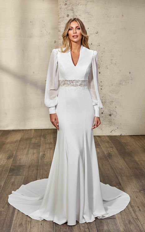 Eddy K Fit-n-Flare wedding gown with ivory Crepe and lace cut-out around waist and long sleeves on blonde haired woman.