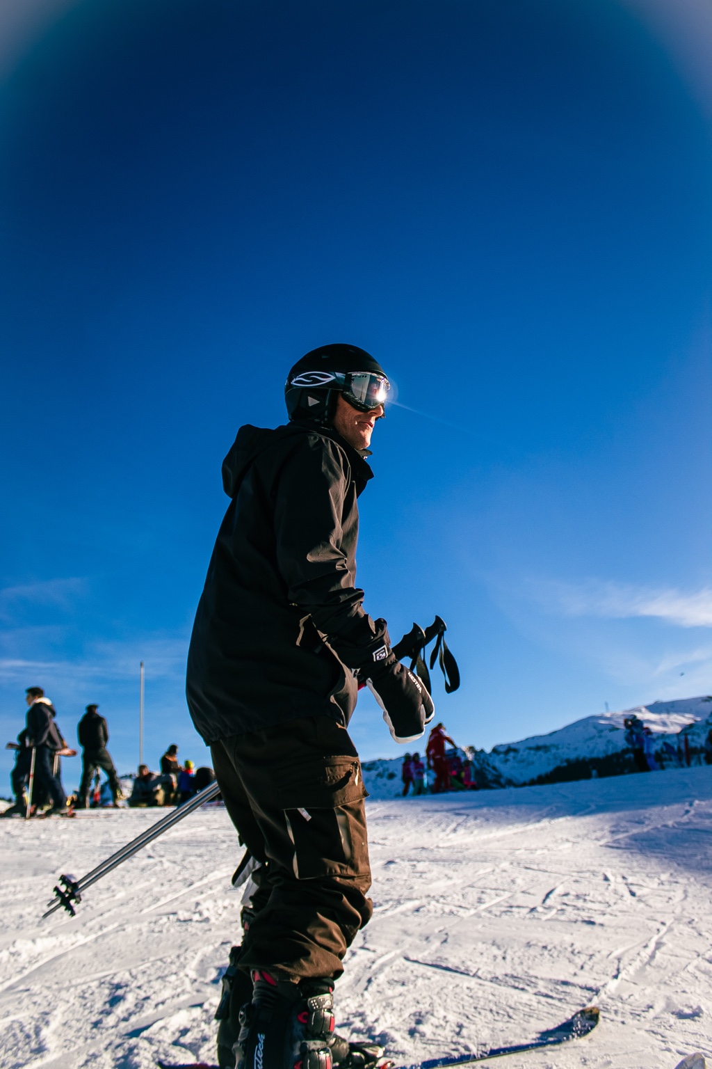 Paul standing on a snowy ski slope beneath a blue sky