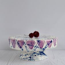 Handmade porcelain cake Stand decorated with slip-trailed petals and glazed in cobalt blue splatters and pink.