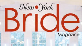 As seen in New York Bride magazine. Bride and groom embrace in elegant, bright venue with floral decor.