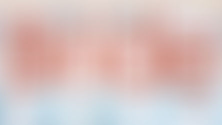 As seen in New York Bride magazine. Bride and groom embrace in elegant, bright venue with floral decor.