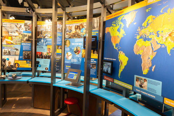 Interactive nuclear power exhibit with world map and displays.