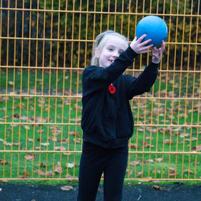 Child catching a ball in her PE lesson