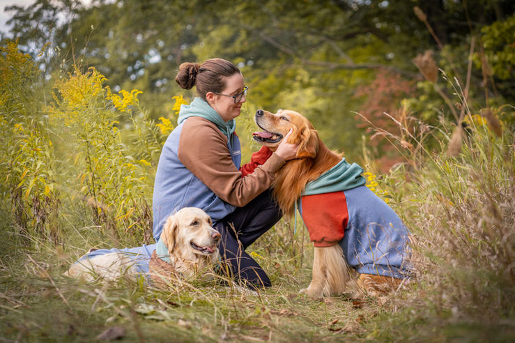 Woman and her golden retrievers in matching hoodies