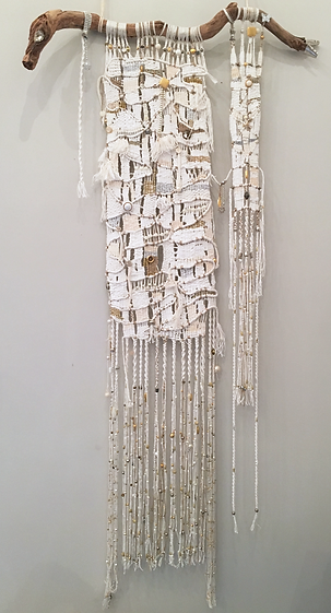 Tissage mural en corde de coton blanc avec inclusions dorées et argentées.