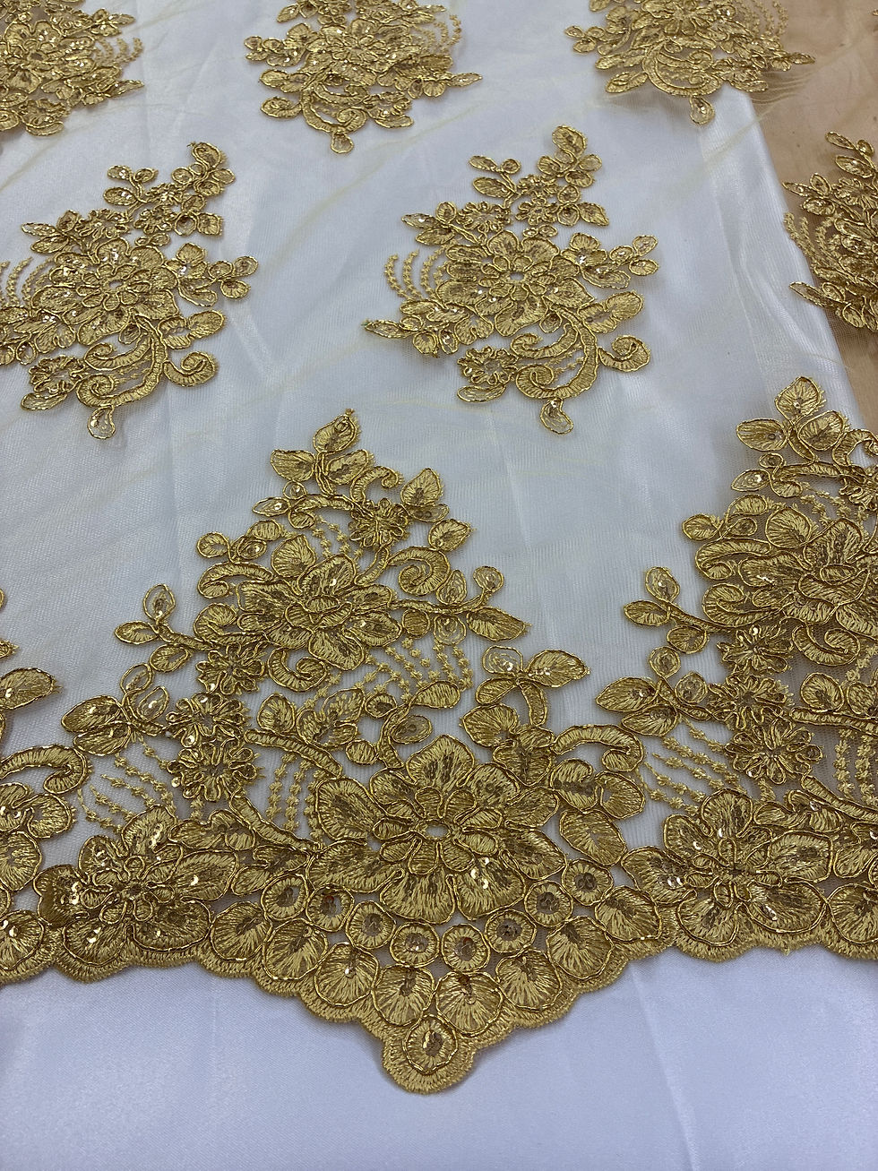 Thumbnail: close up view of gold lace with white lining fabric