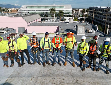 a group of roofers posing for a photo on top of a roof