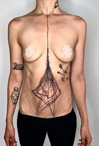 photo showing a chest and stomach tattoo showing an upside down abstract flower with a long line from the collarbons going straight down the stomach, turning into a tulip like flower