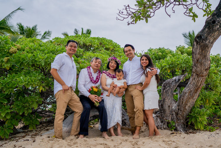 Family posing for photographs on beach in Hawaii, just married with Simple Hawaii Elopements.