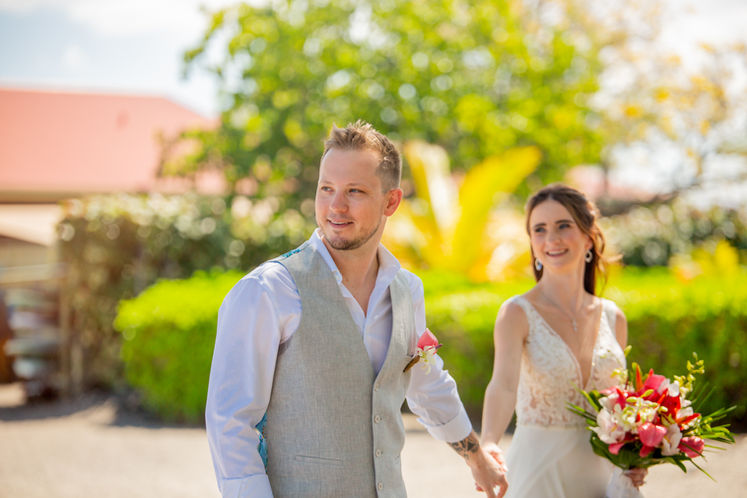 Bride and groom holding hands on beach in Hawaii just married with Simple Hawaii Elopements.