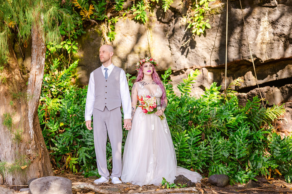 Bride and groom, Deena and Brian, posing against steep cliffs at Kehena Black Sand Beach for their elopement photography with Kona Wedding Officiant.