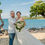 Thumbnail: Bride holds radiant tropical florals beside groom in joyful beachside moment.