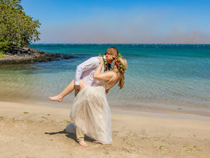 Couple dips for elopement wedding photograph on the shoreline of mau`umae beach elopement big island hawaii with kona wedding officiant