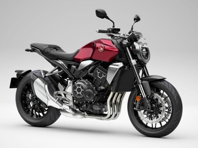 A red and black motorcycle with angular design on display against a plain white background.