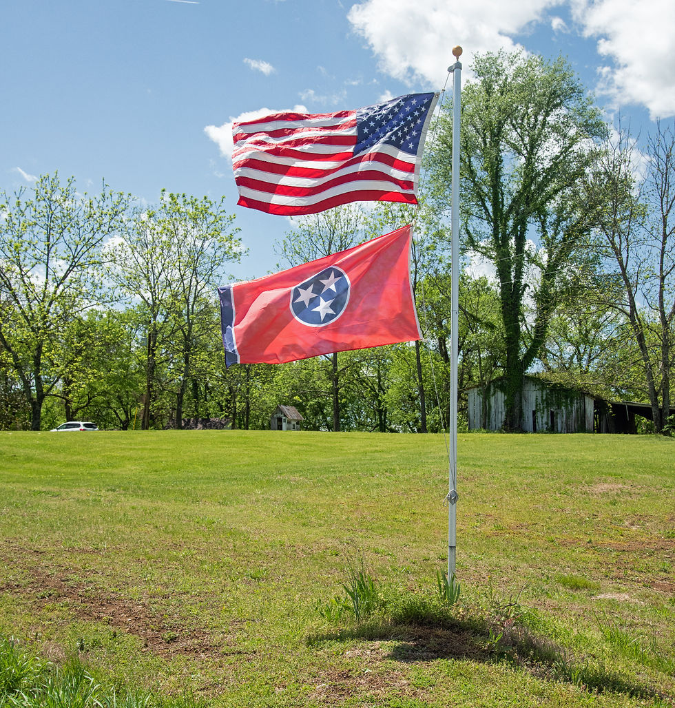 The American flag flies over the Tennessee state flag on the roadside in Giles county, Tennessee.