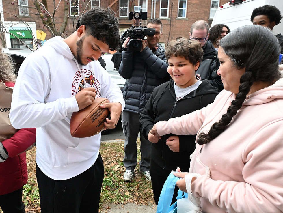 Patriots Kicker Andy Borregales signing a football in Turner Falls. Photo Courtesy: Greenfield Recorder