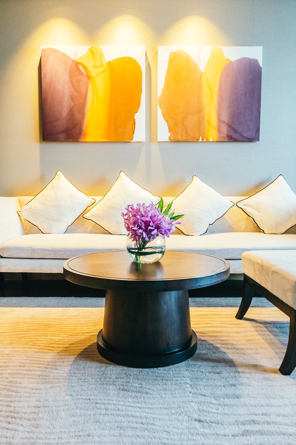 Beige sofa with black center table and purple flowers