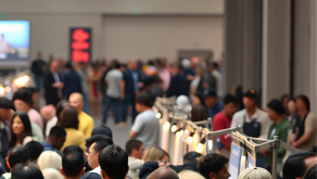 a diverse group of people in a large convention hall