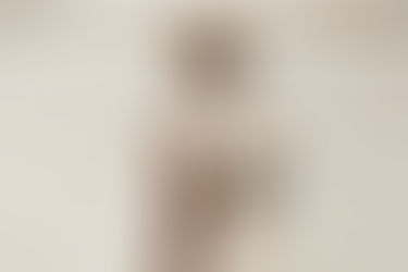 Woman looking sideways next to a wall