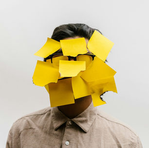 Person with yellow sticky notes covering their face, symbolising cognitive overload and lack of thinking space in modern work environments.